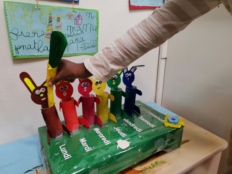 Sur une table, des lapins en carton colorés figurent les jours de la semaine.