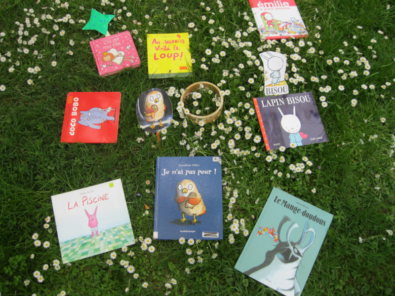 Des livres pour enfants posés dans l'herbe.