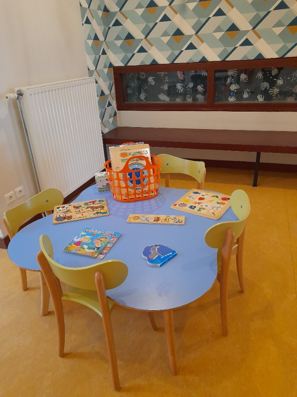 Dans une pièce, une table pour enfants sur laquelle des jouets sont posés.